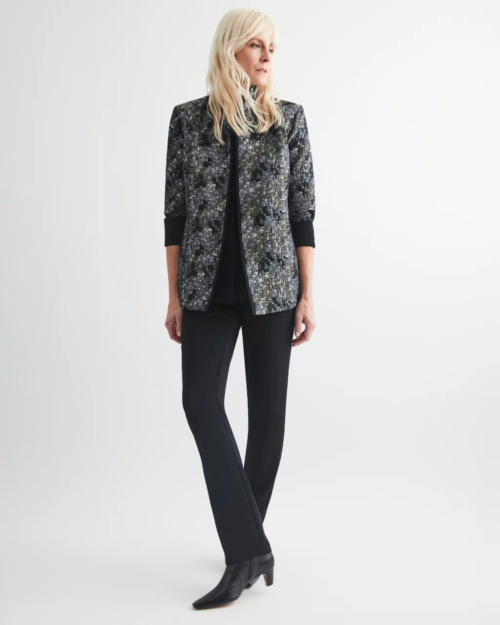 Woman wearing a patterned black and white jacket on a white background